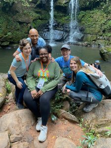 Students pose by a waterfall in Thailand